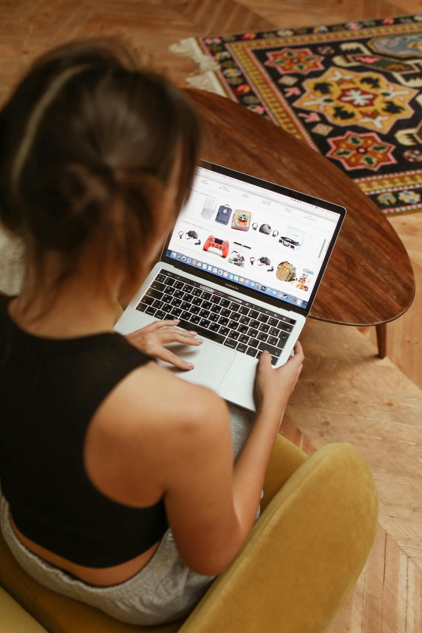 A woman using a laptop for online shopping in a cozy home environment.